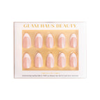 Glam Haus Beauty press-on nails packaging with gold accents on a white background, chrome French tip nails color, almond shaped nails in the package
