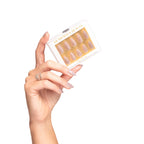 close-up of hand holding Glam Has Beauty press-on nails box. Nails color chrome pink. Nails shape almond.