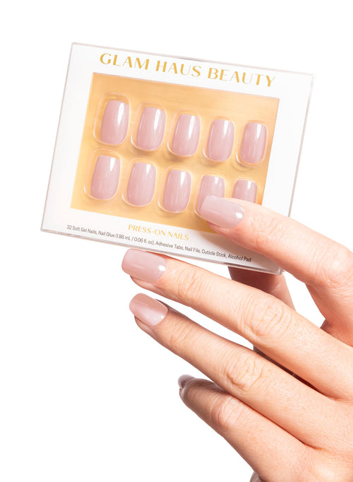 Set of false nails in a Glam Haus Beauty packaging with a hand displaying the nails. Pink color nails, square shape